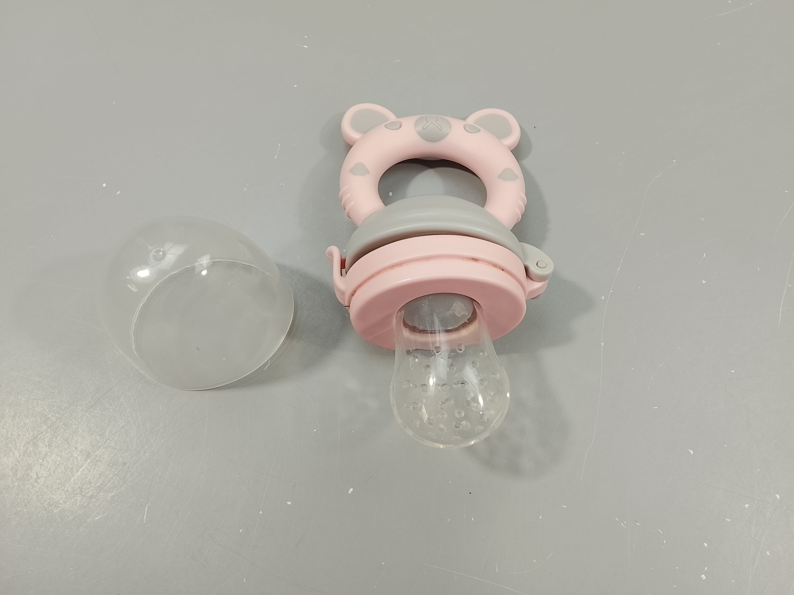 Grignoteuse rose et gris avec  tétine en silicone, sert aussi d'anneau de dentition